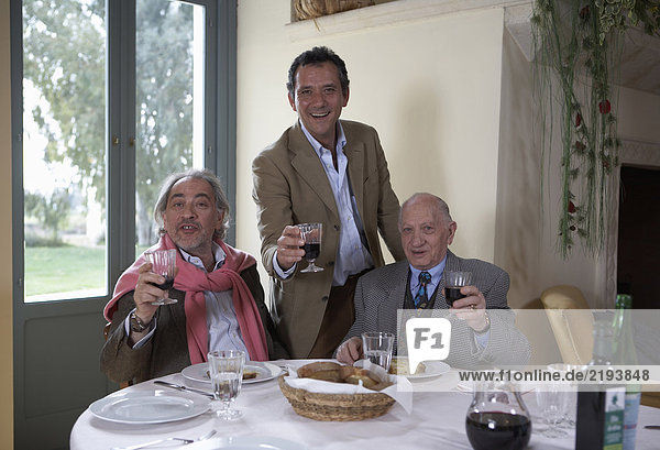Drei Generationen Familie mit Weinglas am Tisch  Portrait
