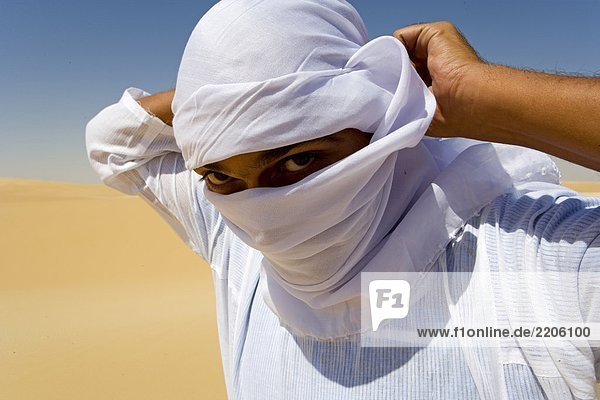 Portrait des Mannes über sein Gesicht mit Kopftuch  großen Sand Meer  zur Oase Siwa  Libysche Wüste Ägypten