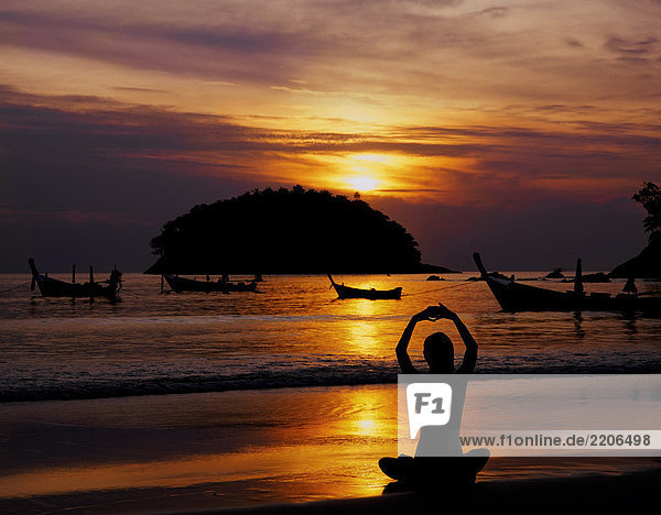 Thailand  Phuket  Kata Beach  Frau meditating at sunset