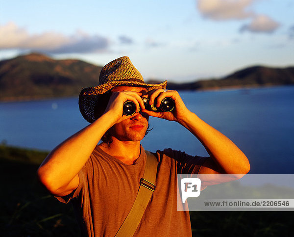 Australien  Queensland  Whitsunday Islands  Lindeman Insel  Mann mit einem Fernglas