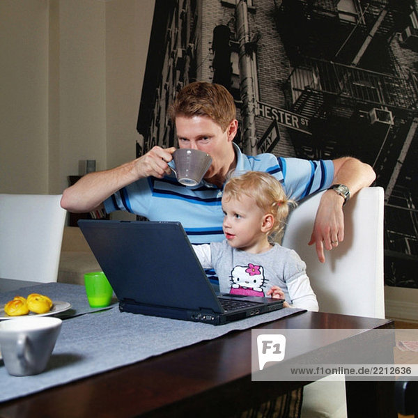 Mann und Tochter am Computer