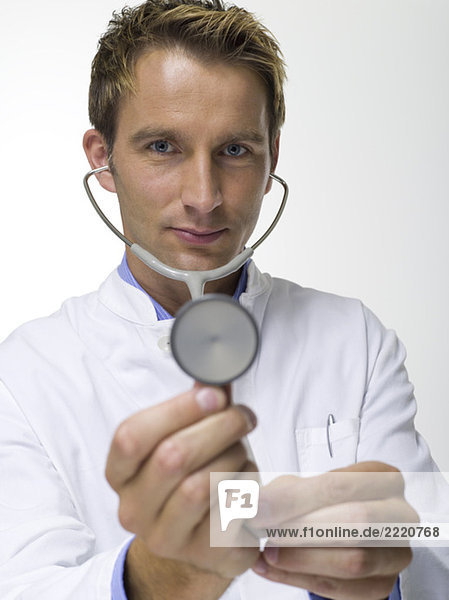 Male doctor holding stethoscope  close-up  portrait