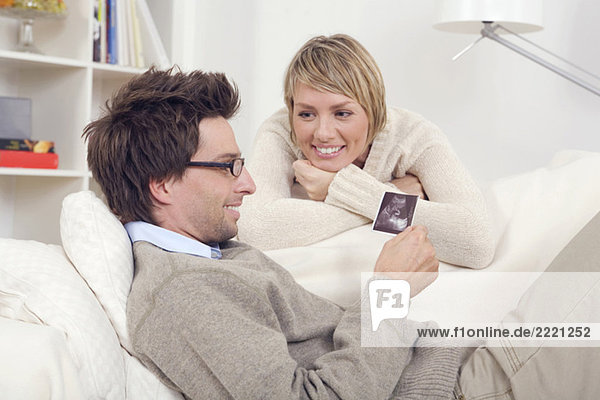 Couple  Man looking at ultrasound photos