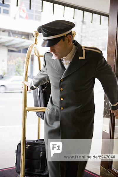 Hotelpage ziehende Gepäckwagen