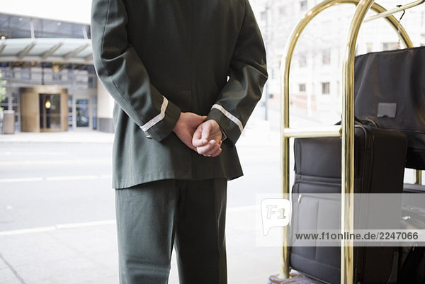 Hotelpage mit Hände hinter dem Rücken