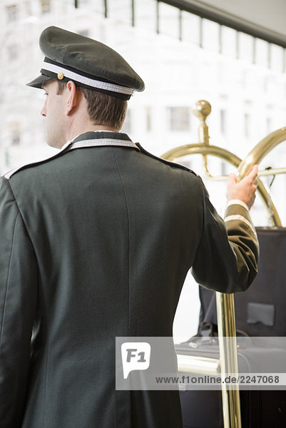 Hotelpage mit Hand auf Gepäckwagen