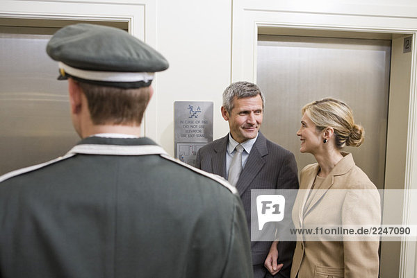 Paar und Hotelpage Aufzug warten