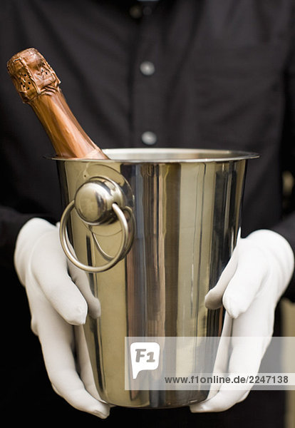 Kellner mit Champagner in Eiskübel