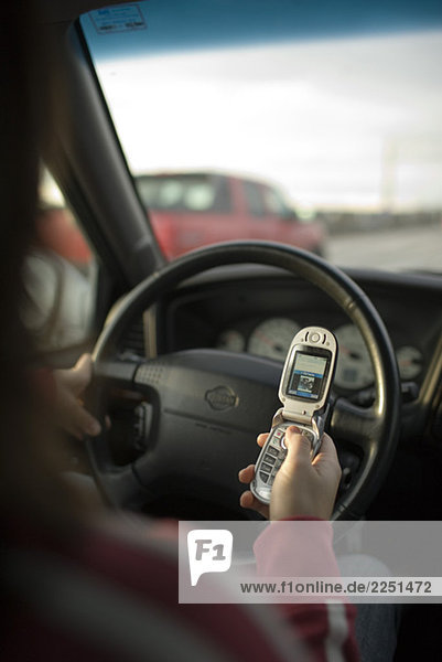 Frau mit ihr Handy während der Fahrt