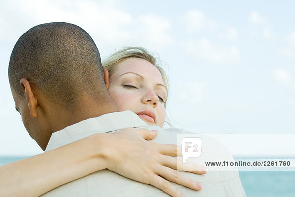 Couple embracing  woman's eyes closed  rear view