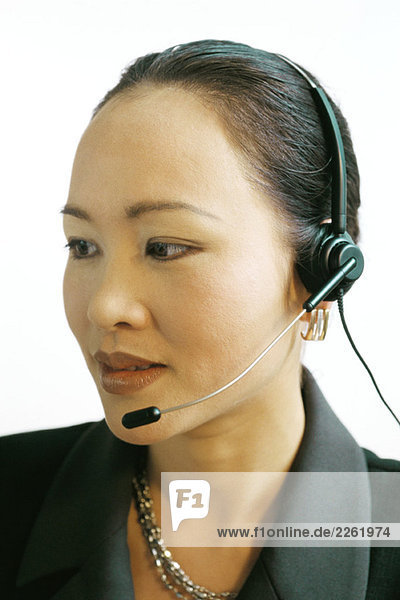 Businesswoman using headset  looking away  close-up