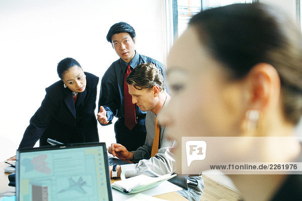 Professionals in office working together  one man looking at camera  selective focus