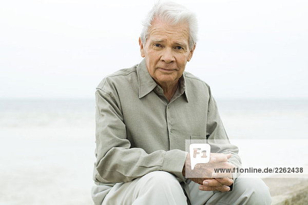 Älterer Mann im Freien sitzend  lächelnd vor der Kamera  Porträt