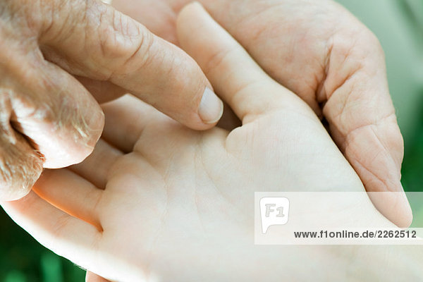 Mann berührt Kinderhand  extreme Nahaufnahme
