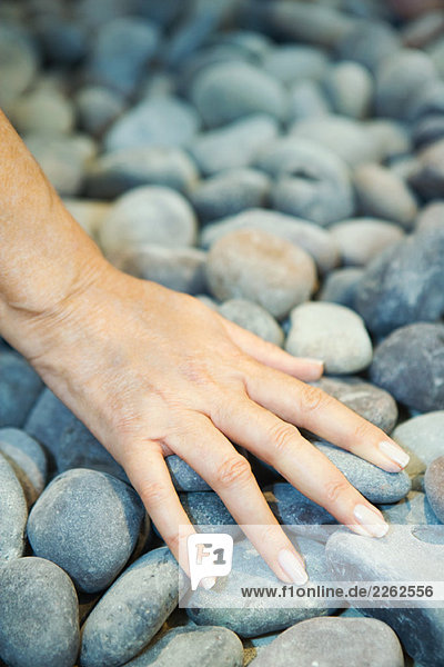 Frau berührt Kieselsteine  abgeschnittene Ansicht der Hand