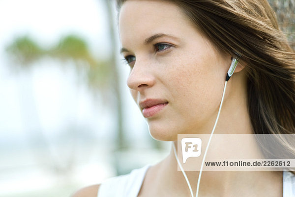 Teenage girl listening to headphones  looking away  close-up