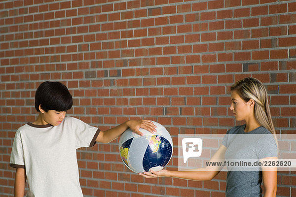 Junge und Frau halten bandagierten Globus zusammen.