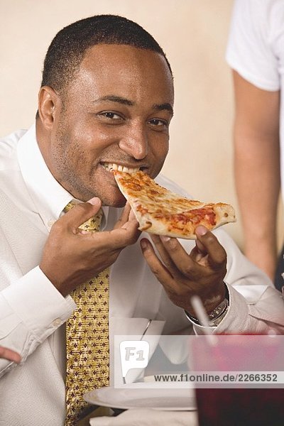 Man biting into a slice of pizza
