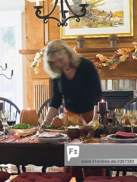 Frau serviert gefüllten Truthahn zu Thanksgiving (USA)