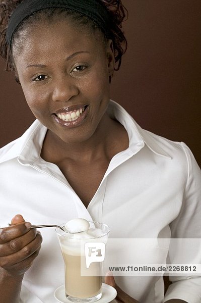 Frau hält Glas Latte Macchiato