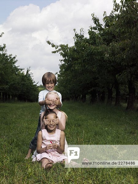Three children playing in a field