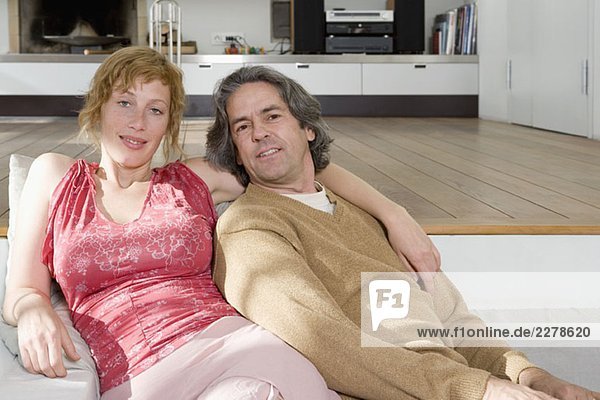 Ein Paar sitzt zusammen auf dem Sofa.