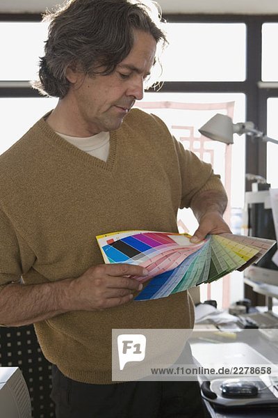 Ein Mann mit Farbmustern in einem Büro.
