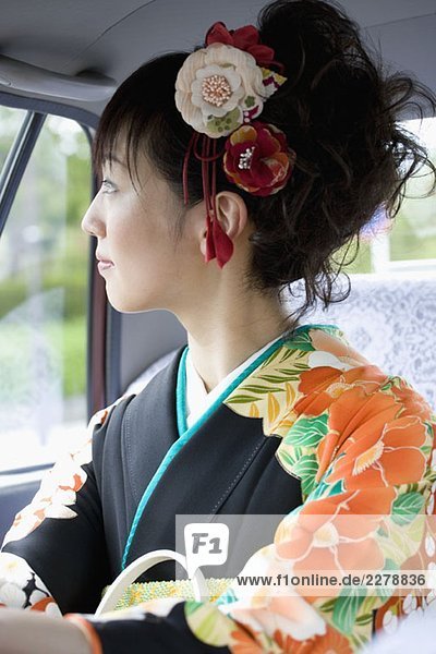 Eine Frau mit Kimono im Auto