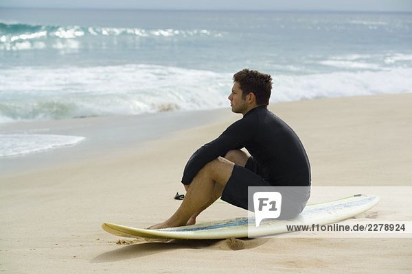 Ein Surfer am Strand sitzend