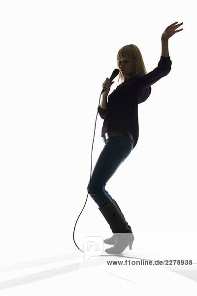 Studioaufnahme einer Frau  die in ein Mikrofon singt.
