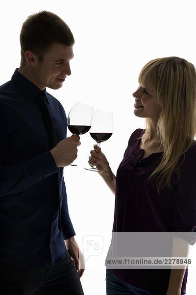 A heterosexual couple toasting wine glasses