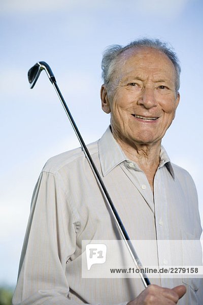 Ein älterer Mann mit einem Golfschläger.