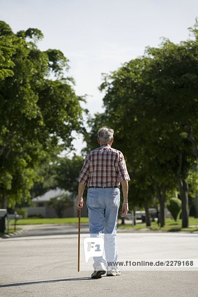 A senior man walking along a street