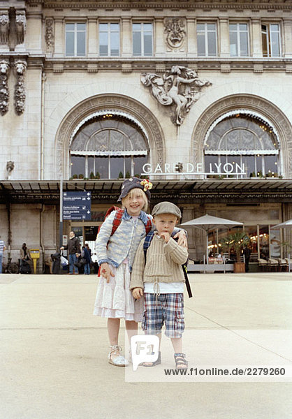 Two children standing in front of the Gare de Lyon  Paris