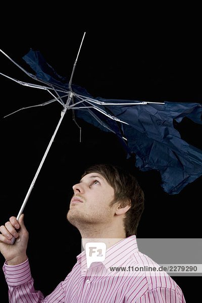 A man holding a broken umbrella