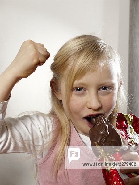 Ein Mädchen isst einen Schokoladen-Weihnachtsmann.