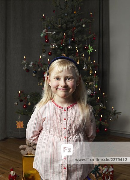 Portrait of a girl in front of a Christmas tree
