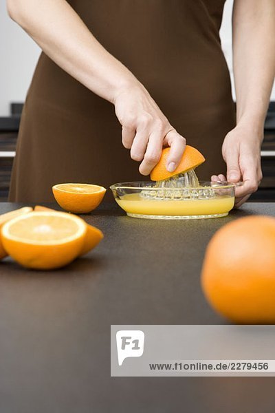 Eine Frau  die Orangen entsaftet.