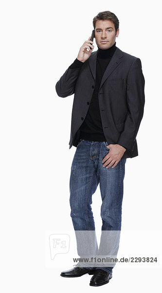 Young man in jeans and jacket  phoning  portrait