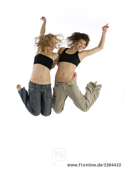 Zwei junge Frauen springen in der Luft.