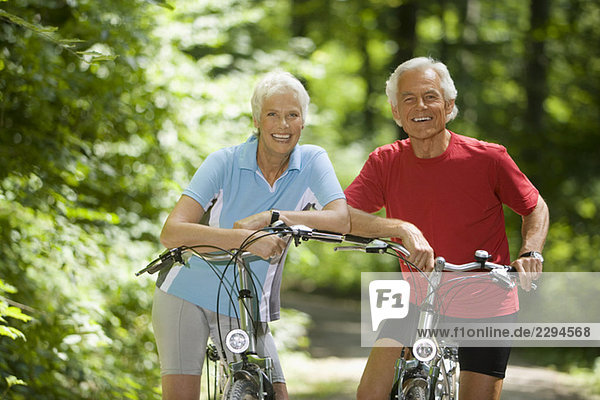 Seniorenpaar mit Fahrrädern  lächelnd  Portrait