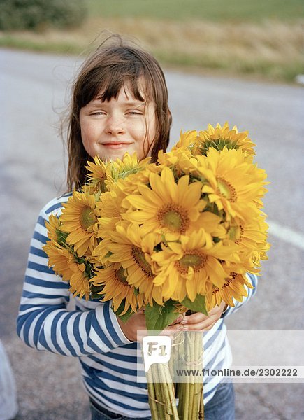 Ein Mädchen mit einem Arm voller Sonnenblumen Schweden