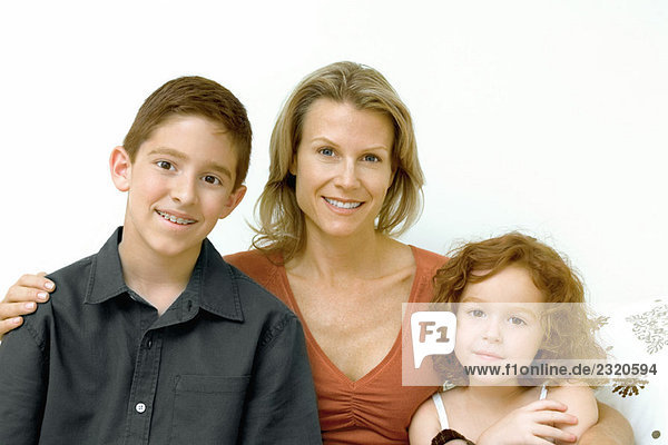 Woman with son and daughter smiling at camera  portrait