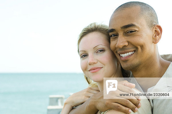 Couple embracing outdoors  smiling at camera together