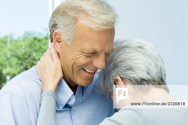 Mature woman leaning her head on husband's chest  close-up