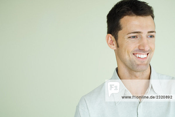 Man smiling  looking out of frame  head and shoulders  portrait