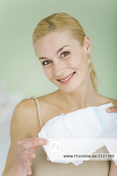 Woman holding baby diaper  smiling at camera