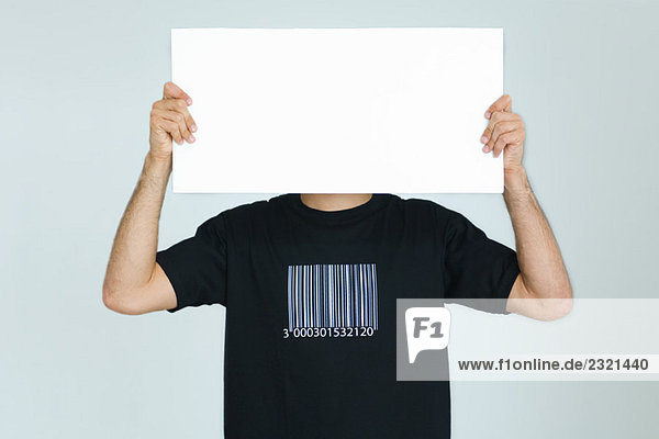 Mann im T-Shirt mit Barcode  der ein leeres Schild vor das Gesicht hält.