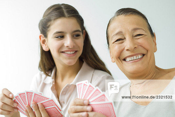 Senior woman and granddaughter playing cards