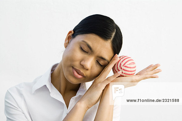 Young woman resting head on hands  holding ball  eyes closed